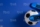 Soccer ball under soccer players feet on blue background.